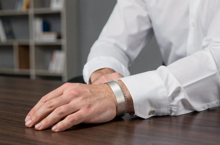 Bracelet homme en or blanc élégant porté avec une chemise blanche dans un bureau moderne